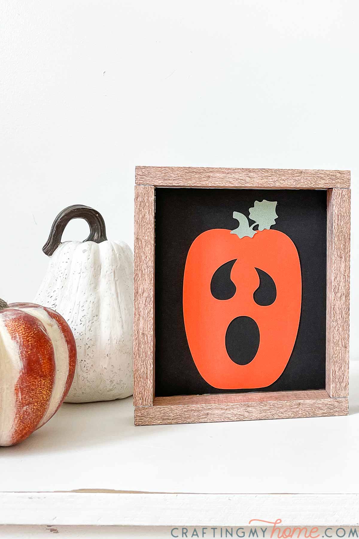 Open-mouthed pumpkin face on a small square paper sign