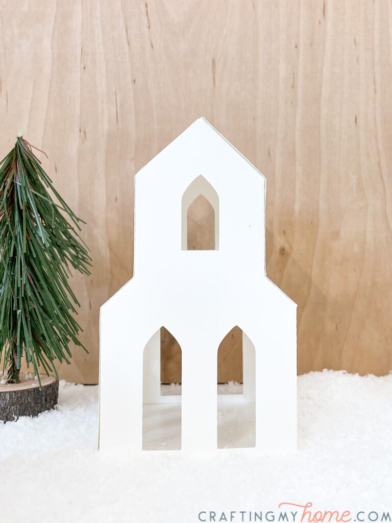 Tall church shaped house in the paper Christmas village DIY. 