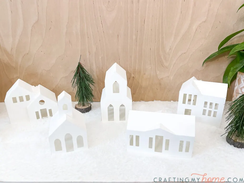 Looking down on a Christmas village made with 5 white paper Christmas housese.