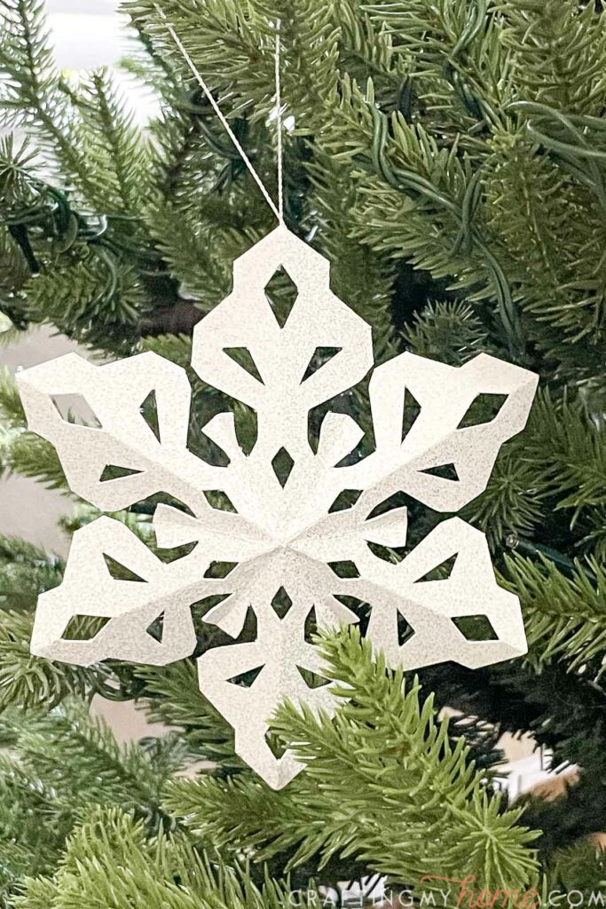 Close up of the glitter painted paper snowflake Christmas ornament. 