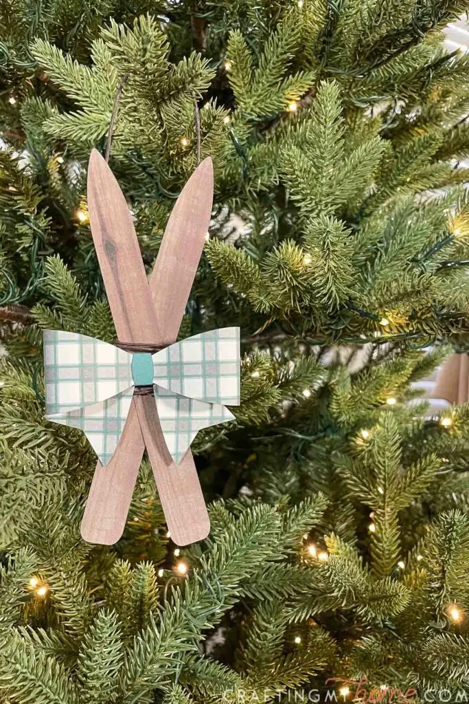 Paper Christmas that looks like vintage wooden skis with a plaid bow on top. 