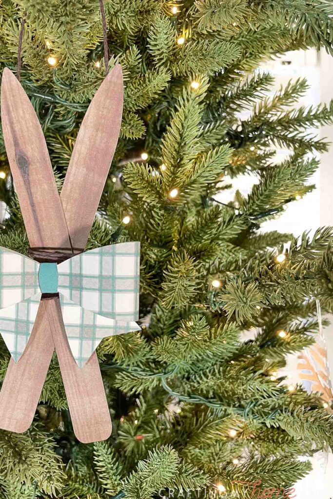Close up of the wooden skis ornament with a green plaid bow on top.