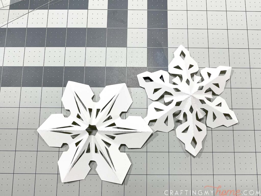 Folding 3D paper snowflakes out of cardstock.