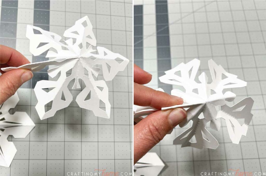 Showing how to fold the two seams on the paper snowflake ornaments. 