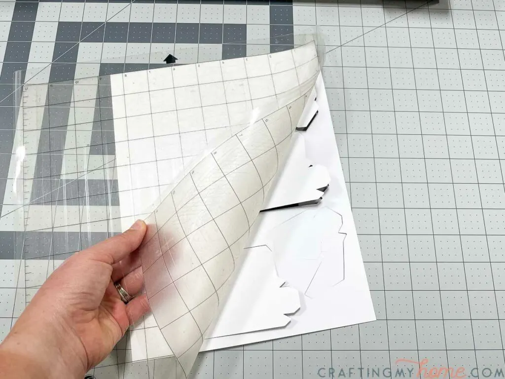 Removing the paper pieces from the sticky cutting mat. 