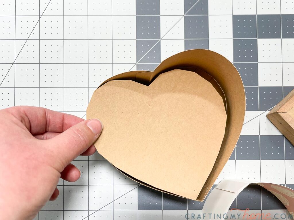 Inserting the bottom reinforcement for extra strength for the paper heart box. 