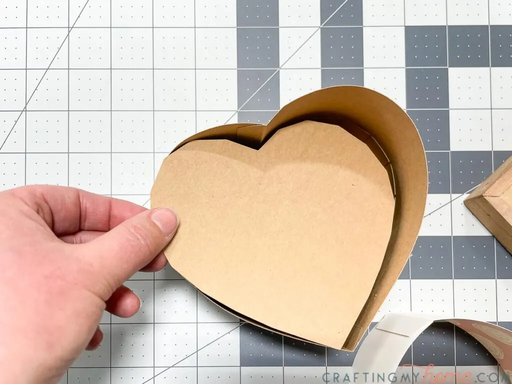 Inserting the bottom reinforcement for extra strength for the paper heart box. 
