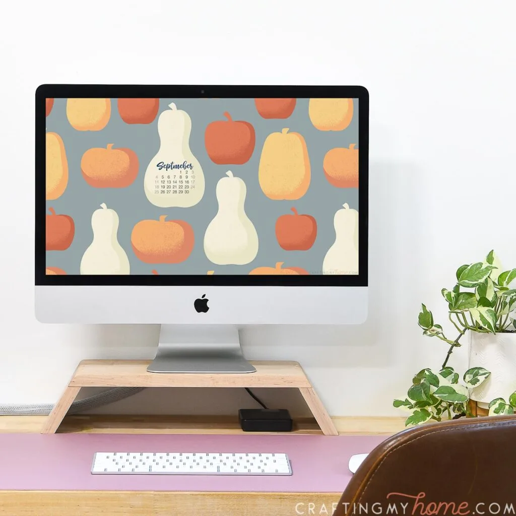 iMac computer on a desk with retro pumpkin digital wallpaper on the monitor. 
