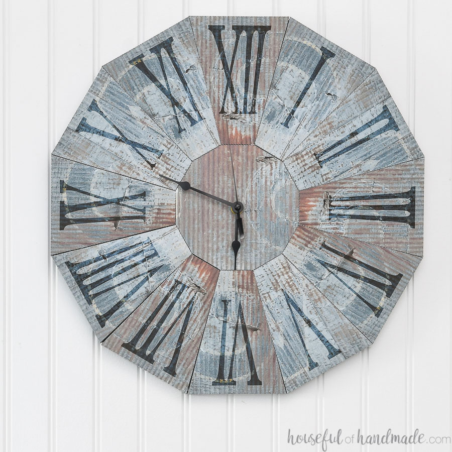 Wall clock that looks like rustic blue steel clock made from paper.